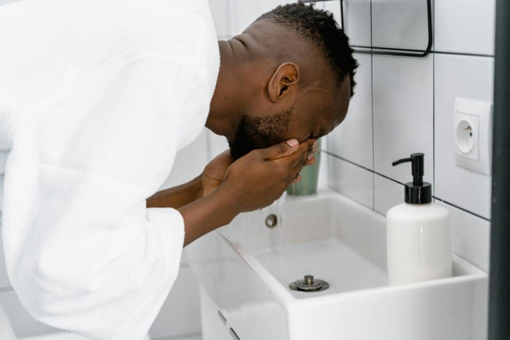 A man splashes cold water on his face as a way to relieve anxiety using the 54321 treatment method