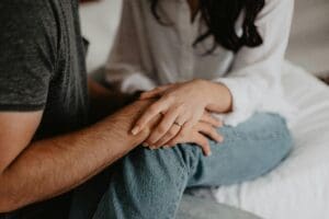 couple sitting together, holding hands, showing support, listening