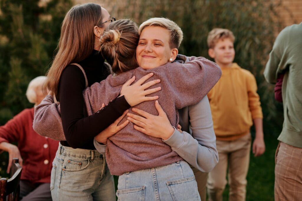 group of women smiling, embracing each other, showing support