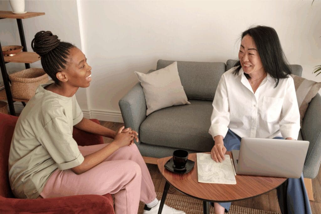 Two people having a supportive conversation during a therapy session.